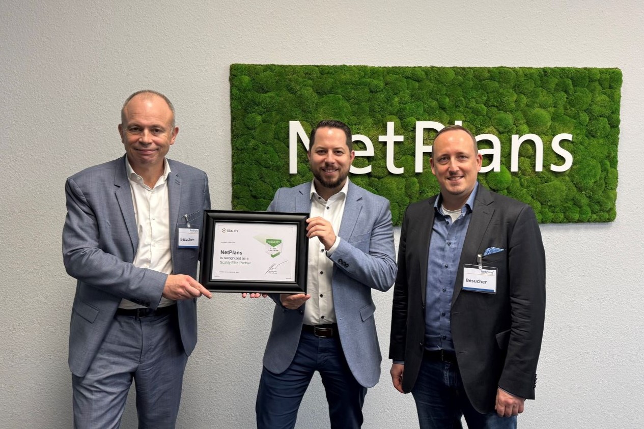 NetPlans Mitarbeiter hält eine Urkunde in der Hand neben 2 Scality Mitarbeitern