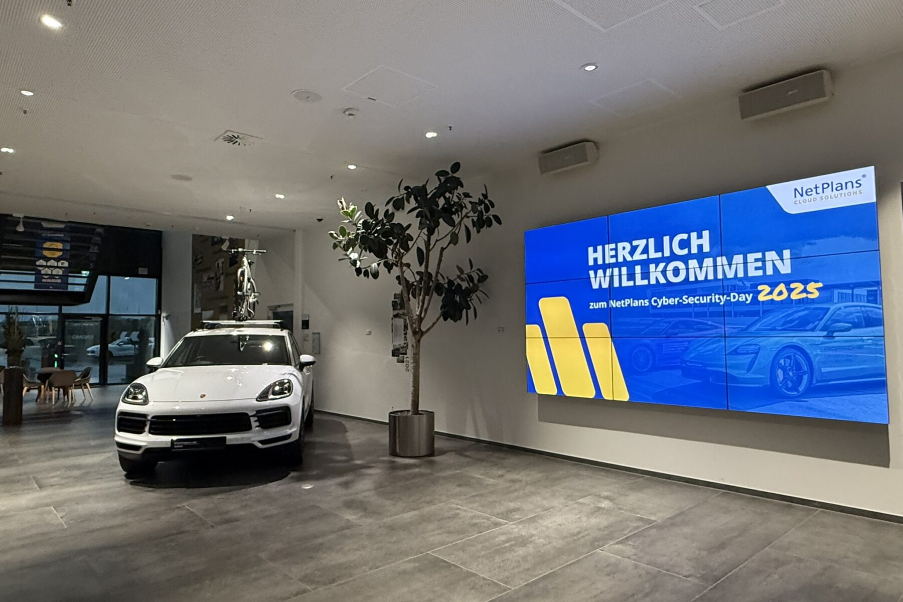 Eingangshallte des Porsche Experience Centers am Hockenheimring mit Display zum NetPlans Cyber Security Day