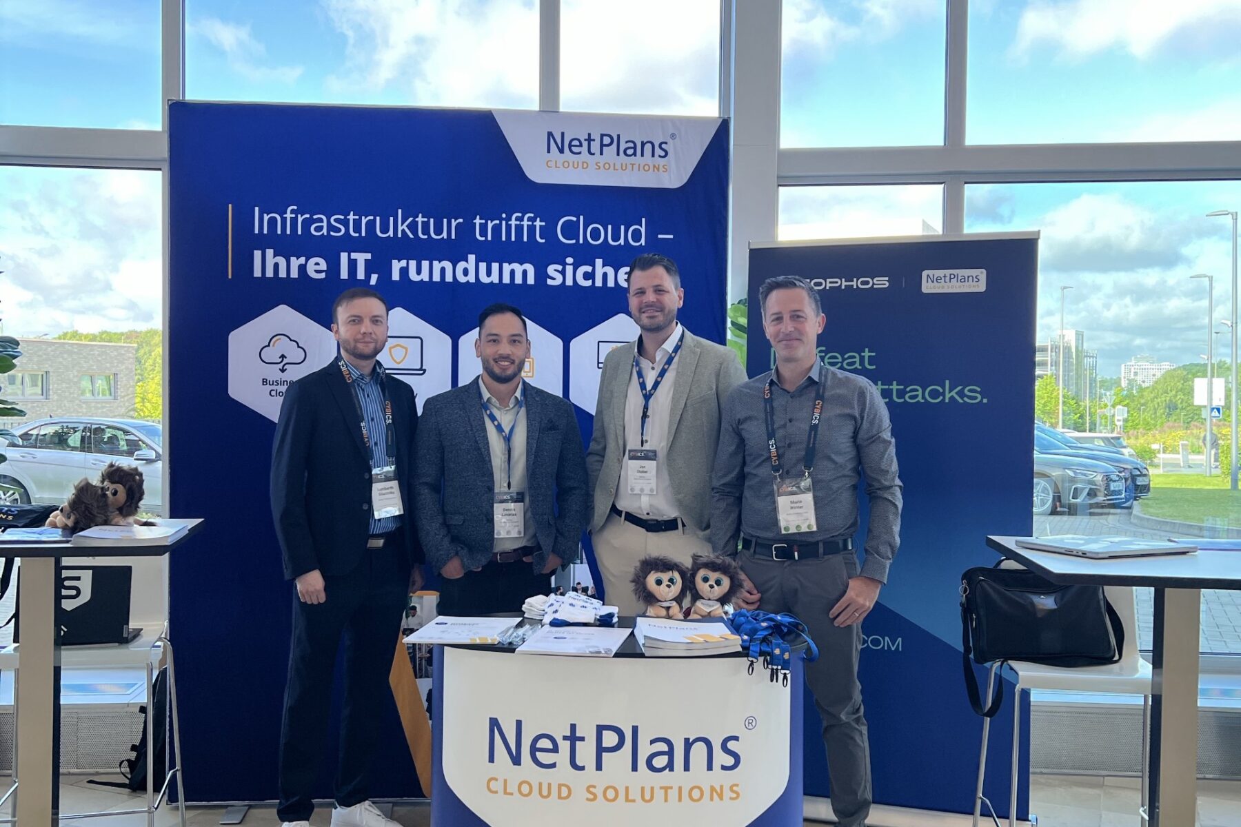 Messestand von NetPlans Cloud Solutions mit vier Mitarbeitern