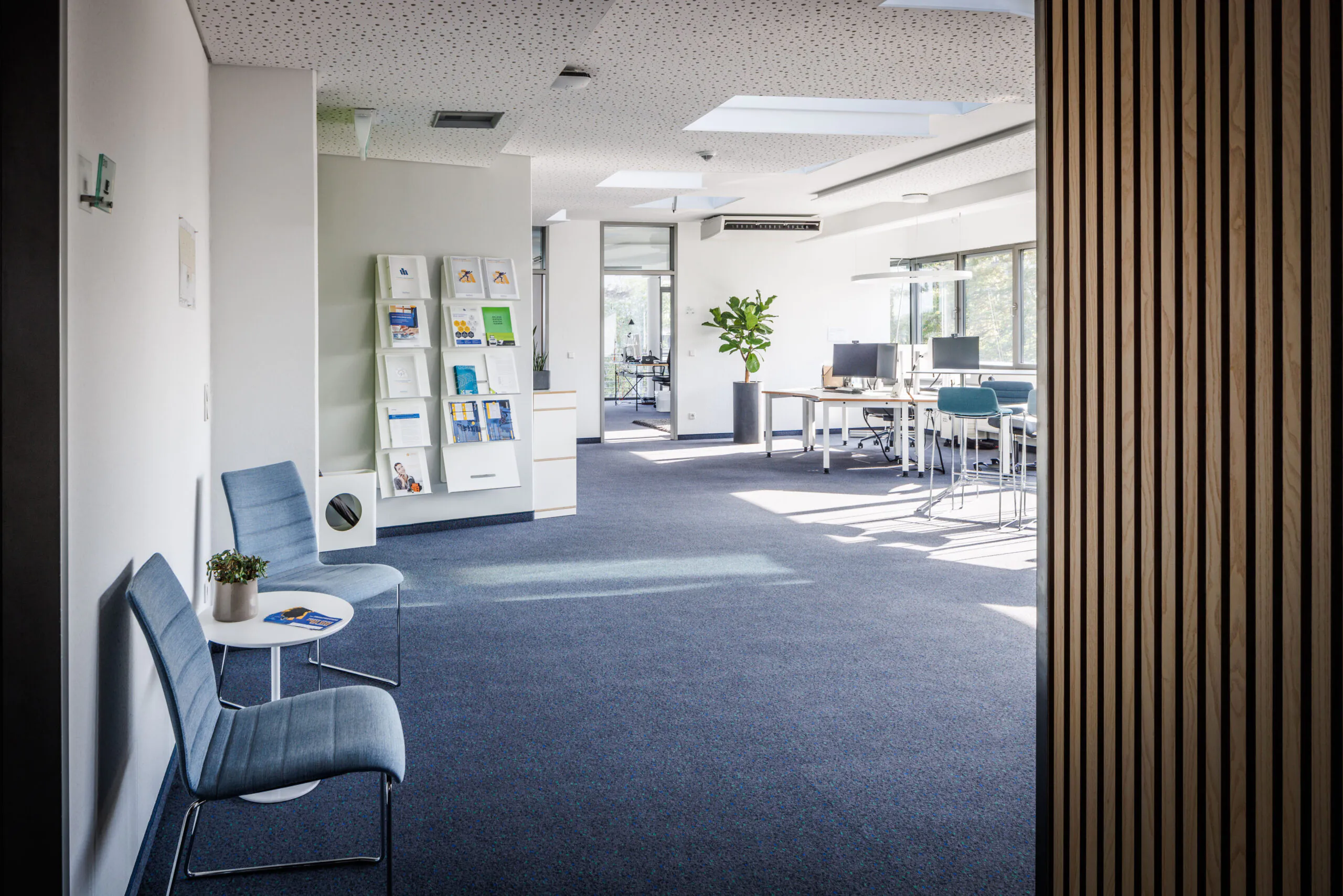 Blick in hellen leeren Büroraum mit Teppichboden und Prospekthalter